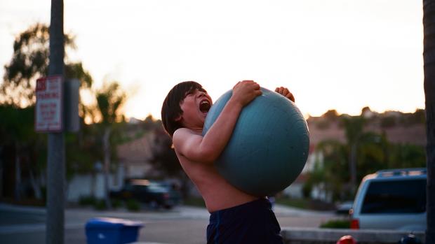 frustrated boy carrying blue ball